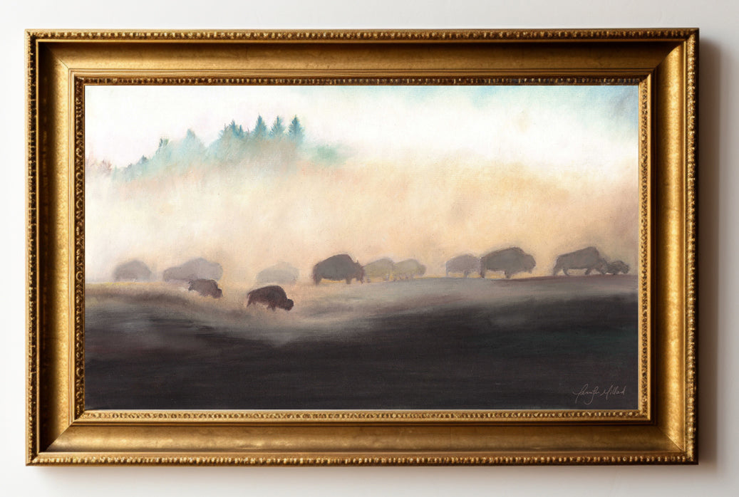 This is an example of a gold frame around a print of a bison herd on the dusty plains.