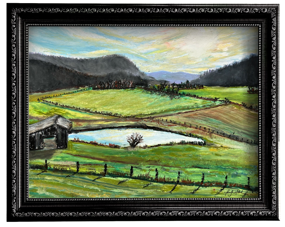 A print of an oil pastel painting of a view of Red Lick Road farmland in the holler in a black frame.